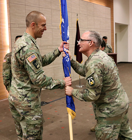 Col. Paul Kassebaum accepts the flag from Brig. Gen. Anthony J. McQueen